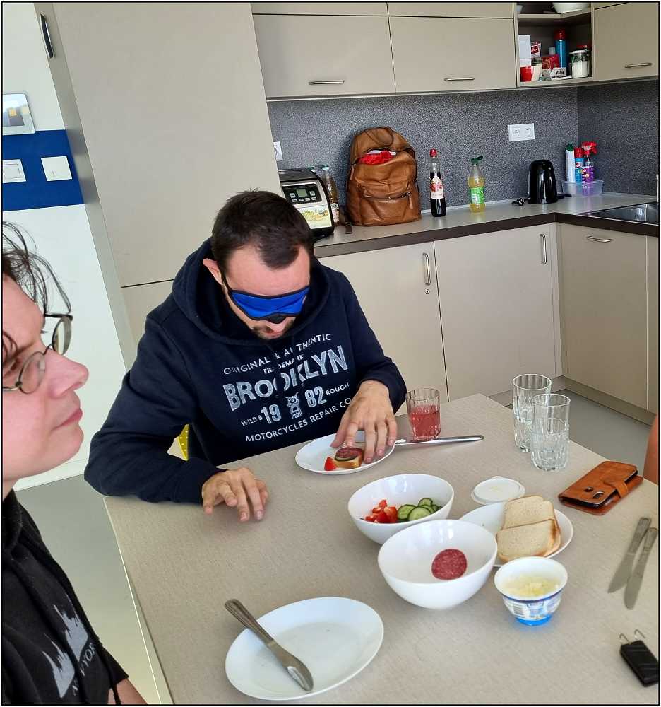 jeden z hostů si chystá svačinku poslepu